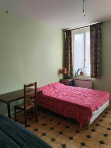 una camera da letto con un letto, un tavolo e una finestra di Studio chez Claudine a Conches-en-Ouche