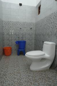baño con aseo y cubo azul en Willy's Home Stay, en Parūr