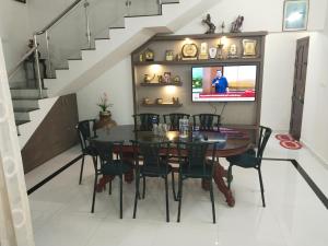 a dining room with a table and a tv at Willy's Home Stay in Parūr