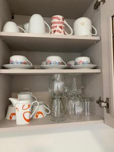 Un armario lleno de platos, tazas y vajilla. en Bluestars Home, en Karlovy Vary