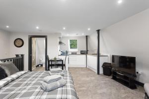 Una sala de estar con una cama y una cocina. en Edinburgh City Penthouse Studio, en Edimburgo
