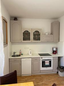 Una cocina con gabinetes blancos y un fregadero. en Bluestars Home, en Karlovy Vary