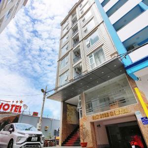 a building with a car parked in front of it at New Star Hotel Vũng Tàu in Vung Tau