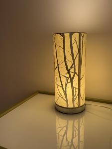 un jarrón sentado en una mesa con una luz en NELL GWYNN HOUSE - Hotel Style POD Room 61, en Londres