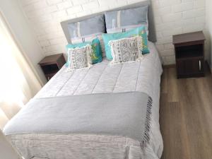 a bed with blue and white pillows on it at Casa Valle Volcanes 3 Dormitorios in Puerto Montt