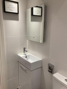 a white bathroom with a sink and a mirror at NELL GWYNN HOUSE - Hotel Room Style POD Room 61 in London +2 photos