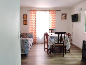 a living room with a table and chairs and a window at Casa Valle Volcanes 3 Dormitorios in Puerto Montt