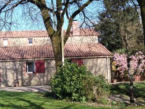 a house with pink flowers in front of it at Les Trois Geais in Les Épesses