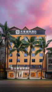 een gebouw met palmbomen ervoor bij Mehood Lestie in Jinghong