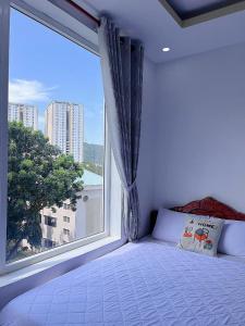 a bed in a room with a large window at New Star Hotel Vũng Tàu in Vung Tau