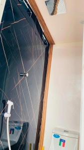 a bathroom with a tiled wall next to a toilet at Musandam Starlight Dhow Cruise in Dibba