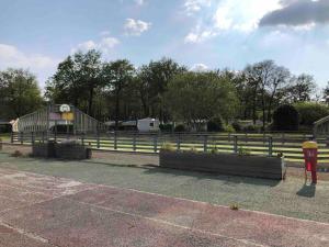 a fence in front of a farm with a building at Bungalow "CONFORT" PUY duFOU 2CH-5pers 720FA in La Boissière-de-Montaigu