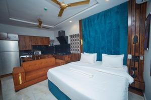 a bedroom with a large bed and a couch at Masters Class Apartments in Mama