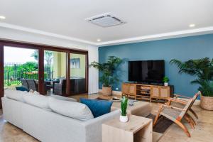 ein Wohnzimmer mit Sofa und Fernseher in der Unterkunft Stunning Remodeled Beachfront Condo! in Tamarindo