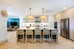eine Küche mit einer großen Insel mit Barhockern in der Unterkunft Stunning Remodeled Beachfront Condo! in Tamarindo