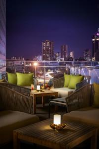 a rooftop patio with tables and chairs and a city skyline at Amari Johor Bahru in Johor Bahru