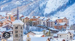 eine Stadt mit einer Kirche im Schnee in der Unterkunft Chalet La Landonne chaleureux pour 2 in La Combe