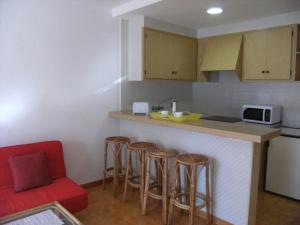レスカラにあるGran Sol C 01のキッチン(カウンター、バースツール、赤いソファ付)