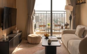 Una sala de estar con un sofá y una ventana grande. en Soho Residence & Apartments by Serenity Living - City Center District 1 - Premium Studios & 2-3 Bedrooms Suite, Next Bui Vien, en Ho Chi Minh