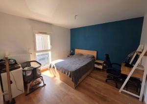 een slaapkamer met een bed en een blauwe muur bij Villa - Le Nids sur Orge in Villiers-sur-Orge