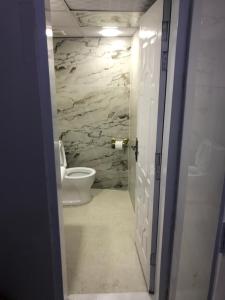 a bathroom with a toilet and a stone wall at Aqua pura Lodges By Ansar Qureshi in Murree