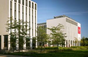 a large white building with a sign on it at Leonardo Royal Hotel Munich in Munich