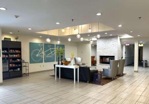 a living room with a table and chairs and a fireplace at Best Western Erie Inn & Suites in Erie