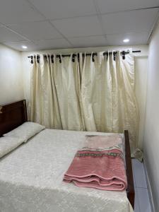 a small bed in a room with a curtain at Aqua pura Lodges By Ansar Qureshi in Murree