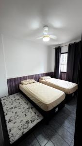 a bedroom with two beds and a ceiling at Apê dos Meninos no Forte in Praia Grande +22 photos