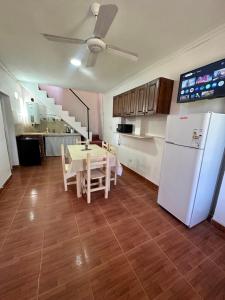 a kitchen with a table and a white refrigerator at Cabañas & Apart Yki Shamuaika in Capilla del Monte