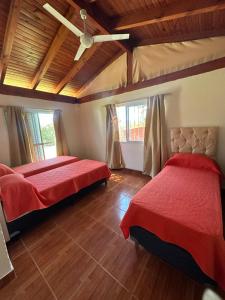 a bedroom with two beds and a wooden ceiling at Cabañas & Apart Yki Shamuaika in Capilla del Monte