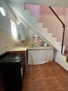a kitchen with a sink and a counter with a staircase at Cabañas & Apart Yki Shamuaika in Capilla del Monte