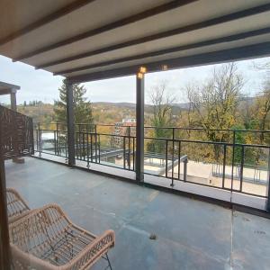 Vrnjačka BanjaにあるAPARTMANI PORTA INFINITAS centarの市街の景色を望むバルコニー(ベンチ2台付)