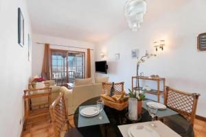 a living room with a table and chairs and a couch at Cozy apartment with sea view - 70 m² in Acantilado de los Gigantes