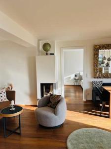 a living room with a chair and a fireplace at Traumhaus mit herrlichem Blick über Graz in Sankt Veit am Vogau