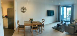 a living room with a table and chairs and a kitchen at Spacious City Centre 2 Bedroom Apartment in Liverpool