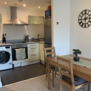 a kitchen with a table and a stove and a sink at Spacious City Centre 2 Bedroom Apartment in Liverpool