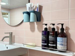 a bathroom shelf with three bottles on it next to a sink at Forest SB02 in Seoul +75 photos