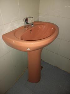 Un lavabo naranja en un baño con un foso en Mara Safaris BNB, en Bomet 9 fotos más