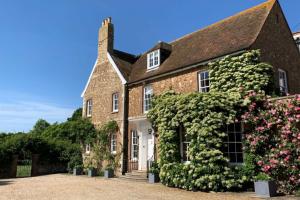 an old brick house with flowers on it at Butley Priory Farmhouse 12 in Woodbridge