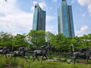 a statue of horses running in a park with tall buildings at Forest SB02 in Seoul