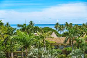um resort com palmeiras e o oceano ao fundo em Beautiful Ocean View Condo Steps To The Beach em Tamarindo