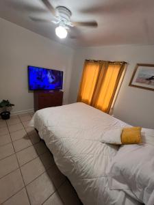ein Schlafzimmer mit einem Bett und einem Flachbildfernseher in der Unterkunft Central Phoenix Value Stay Yellow Room in Phoenix