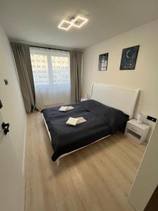 Un dormitorio con una cama grande con dos toallas encima. en Stylish apartment in the heart of the city near Aupark and the Main Station, en Košice