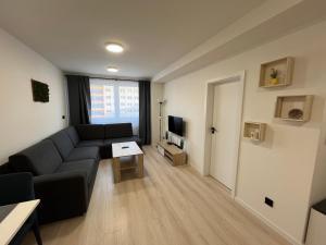 Una sala de estar con un sofá y un televisor. en Stylish apartment in the heart of the city near Aupark and the Main Station, en Košice
