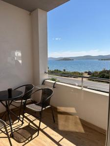 a balcony with a table and chairs and a view of the ocean at Galešnjak in Sveti Petar
