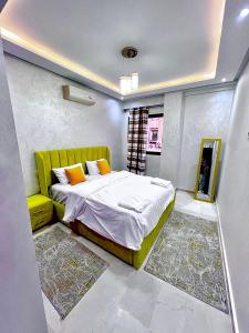 a bedroom with a bed with a green headboard at Marrakech Gueliz APPART ESSADIK in Marrakech