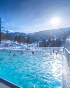 a group of people in a swimming pool in the snow at Très beau studio pieds des pistes tout rénové in Risoul