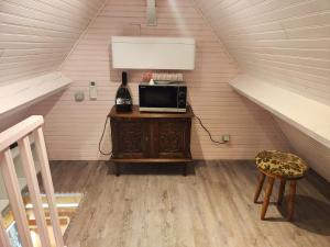 a attic room with a tv and a chair at Chambre maison Normandy in Lieurey