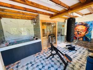 a room with a tub and a large painting on the wall at Chambre maison Normandy in Lieurey +2 photos